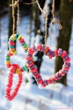 two hearts hanging from strings in the snow