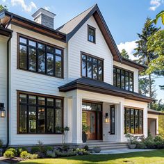 a large white house with lots of windows on it's sides and front porch