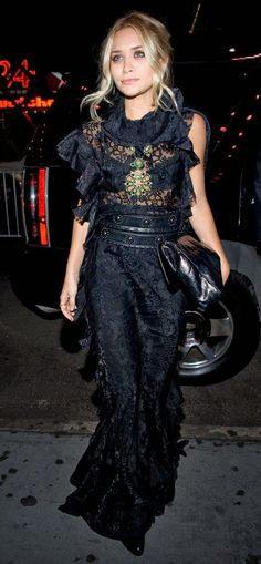 a woman in black dress walking down the street