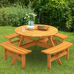 a picnic table with two benches in the grass