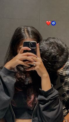 a woman taking a selfie in front of a mirror with her cell phone up to her face