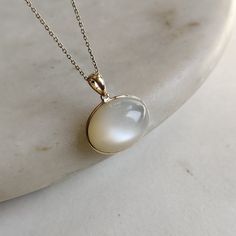 ITEM DESCRIPTION: >>The pendant is made from Solid 14K Yellow Gold. Gemstone used is absolutely natural and ethically sourced.  >>Natural White Moonstones cabochon with bezel setting are studded on it with utmost precision.  >>This is a minimalist design and is absolutely hassle-free and everyday jewelry.  ✓ Gem: White Moonstone ✓ Gem size: 14x19 mm oval ✓ Gem weight: 17.18 carats ✓ Gold purity: 14K (58.33% approx.) ✓ Gold weight: 0.58 grams  ✓ Gross weight: 4.02 grams The Gold purity is guaranteed and it comes with authentic 14K gold hallmark. Since these Pendants are handmade, they are Nickel/Lead FREE.  CUSTOMIZATION: --> You can choose your own gemstone as well. --> Main Gemstone can be substituted with the gem of your choice. --> Kindly drop a message for the same. CUSTOMER SUPPORT: - Moonstone Jewelry Set, Luxury Si Clarity Moonstone Jewelry, White 14k Gold Jewelry With Round Stone, Yellow Gold Moonstone Gemstone Jewelry, Oval Moonstone Yellow Gold Jewelry, Yellow Gold Moonstone Jewelry With Oval Shape, White Moonstone Ring With Polished Finish, Formal Yellow Gold Moonstone Jewelry, Elegant Gold Moonstone Ring With Large Stone