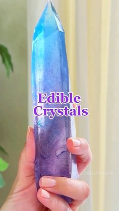 a woman holding up a purple crystal with the words edible crystals on it