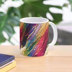 a colorful coffee mug sitting on top of a wooden table