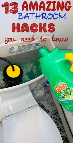 a toilet with the lid open and a green sprayer in it next to a sign that says, 13 amazing bathroom hacks you need to know