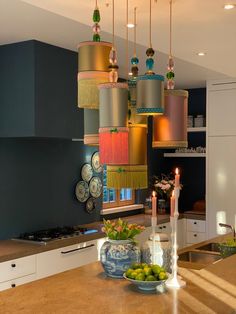 a kitchen filled with lots of counter top space and lights hanging from the ceiling above it