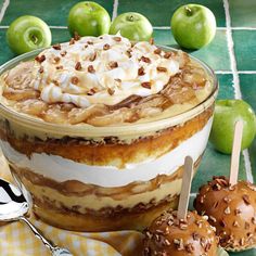 an apple dessert with whipped cream and caramel on top, sitting next to apples