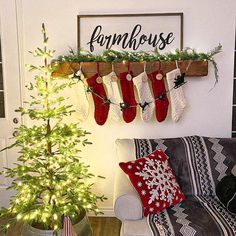 christmas stockings hung on the wall next to a small tree in front of a couch