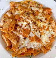 a white plate topped with cheesy pasta and sauce