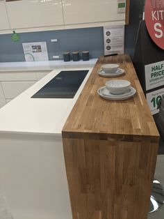 a kitchen island with plates on it in a store display area next to the counter