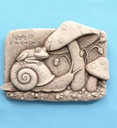 a ceramic plaque that says, enjoy life in the slow lane with snails and mushrooms on it