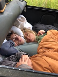 two people sleeping in the back of a truck