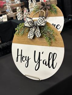 a wooden sign that says hey y'all hanging on a table with other items