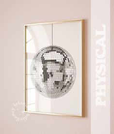 a mirror with a disco ball hanging from it's side next to a wall