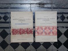 two books sitting on top of a tiled floor