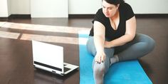 a woman is sitting on the floor with her laptop