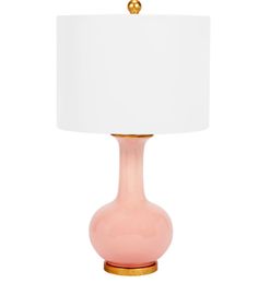 a pink table lamp with a white shade on the top and gold trim around the base