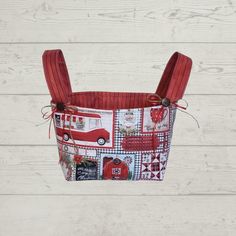 a red and white bag with patches on the front is hanging from a wooden wall