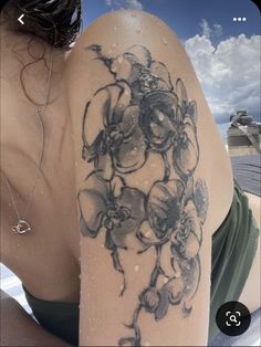 a woman's arm with flowers on it and the back of her shoulder is covered in snow