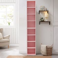 a living room with a pink shelf next to a white chair and rug on the floor