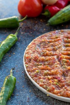 a close up of a plate of food on a table with peppers and other vegetables