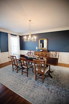 a dinning room with blue walls and wooden furniture in the dining room, along with an area rug that matches the hardwood flooring