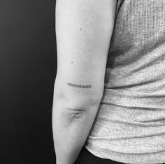 a woman's arm with a black and white line tattoo on her left arm