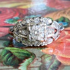 an antique diamond ring sitting on top of a table