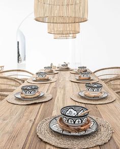 a wooden table topped with plates and bowls