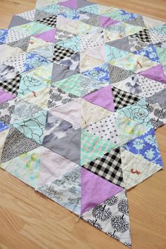 a patchwork quilt is laying on the floor with it's edges cut off