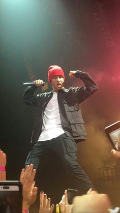 a man standing on top of a stage with his arms in the air