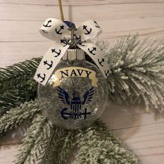 an ornament hanging from a christmas tree with the navy seal and anchor on it