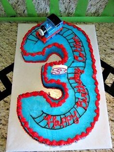 a birthday cake with a train on it and the number five in red, blue and white frosting