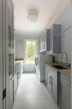 an image of a long narrow white kitchen