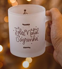 a hand holding a coffee mug with the words feliz nabil sorumha written on it