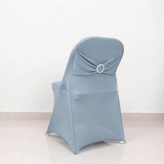 a blue chair sitting on top of a tiled floor next to a white wall with a ring around the back of it