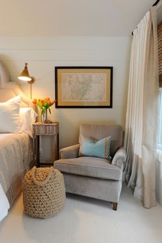 a bedroom with a bed, chair and pictures on the wall