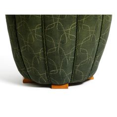 an upholstered green planter with leaves on it