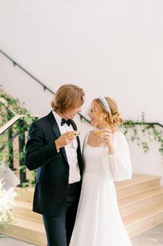 a man in a tuxedo standing next to a woman in a white dress