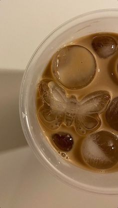 a cup filled with liquid and ice on top of a table