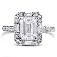 an emerald cut diamond ring set in 18k white gold with diamonds around the band