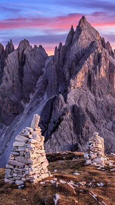 the mountains are covered in rocks and grass as the sun is setting on top of them