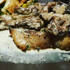 a close up of food on a plate with broccoli and potatoes in the background