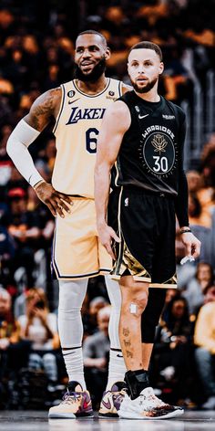 two basketball players standing next to each other in front of an arena full of people