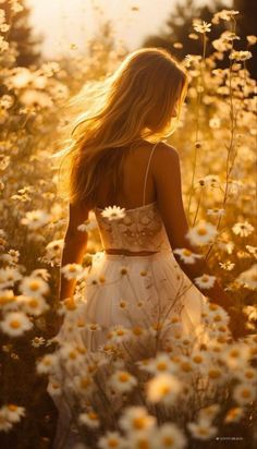 a woman walking through a field of daisies