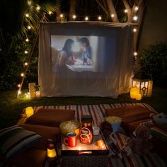 an outdoor movie screen with lights around it