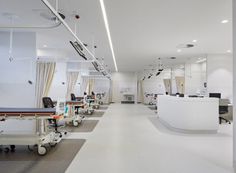 an empty hospital room with medical equipment on the floor and lights hanging from the ceiling