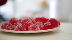 a white plate topped with red candies on top of a table