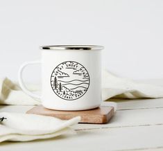 a white coffee mug sitting on top of a wooden coaster