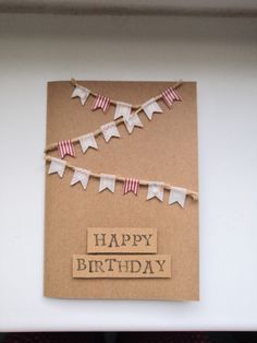 a birthday card with bunting flags and the words happy birthday written on it in brown paper